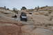1991 Ford Bronco - Jeep Wrangler navigates a challenging off-road course in a desert landscape.