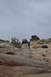 1991 Ford Bronco - A group of people watch as a vintage truck navigates a steep, rocky trail under an overcast sky.