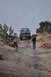1991 Ford Bronco - A dark gray Ford Bronco navigates a steep, rocky terrain with onlookers observing.