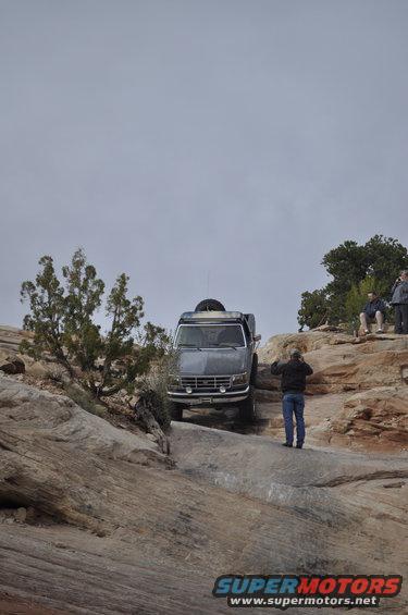 Gray 1992 Ford Bronco driving off-road on a rocky trail