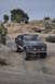 1991 Ford Bronco - A lifted Ford Bronco navigates a steep, rocky trail with two onlookers observing from above.