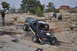 1991 Ford Bronco - A dark blue 1991 Ford Bronco navigates a challenging rocky incline in a desert landscape.