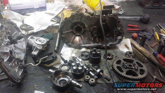 Disassembled transmission components and tools spread across a workbench