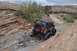 1991 Ford Bronco - A gray Jeep Wrangler navigates a challenging rocky off-road trail in a desert landscape.