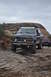 1991 Ford Bronco - A dark blue 1991 Ford Bronco navigates a , rocky terrain, with another vehicle visible behind it.