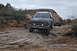 1991 Ford Bronco - Two off-road vehicles navigate a challenging rocky terrain under an overcast sky.