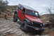 1991 Ford Bronco - A red Jeep Wrangler Rubicon navigates a challenging rocky trail, its off-road capabilities.