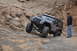 1991 Ford Bronco - Jeep Wrangler navigating a challenging rocky trail with a person observing.