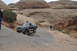 1991 Ford Bronco - A Ford Bronco navigates a challenging rocky terrain in a desert landscape.