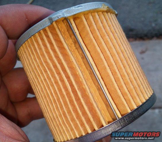 Oil filter with pleated paper element held by a hand