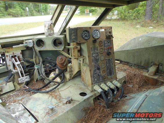 Interior of a military vehicle showing a complex dashboard with gauges and switches