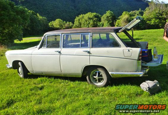 Station wagon with open tailgate and picnic items on grass