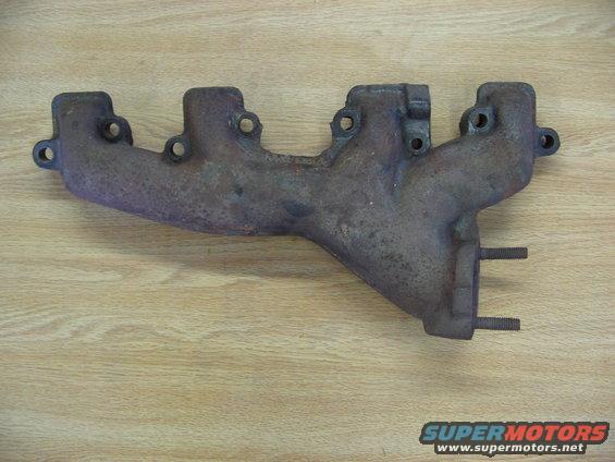 Exhaust manifold with studs on a wooden surface