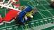 1989 Ford Bronco - A model engine, painted blue with yellow wiring, sits on a cutting mat next to model kit parts.