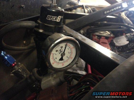 Close-up of an UPGR8 fuel pressure regulator and gauge, showing fuel lines and wiring