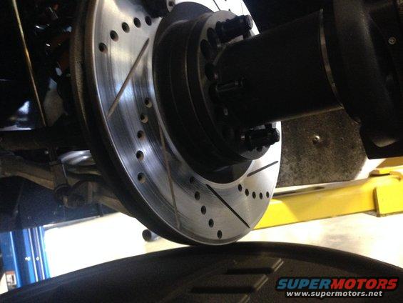 Drilled and slotted brake rotor with black hub and lug nuts