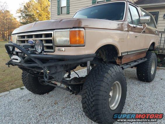 Lifted brown Ford Bronco with aftermarket bumper and winch