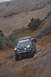 1991 Ford Bronco - Two SUVs navigate a steep, rocky off-road path in a desert canyon.