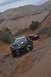 1991 Ford Bronco - Two off-road vehicles navigate a steep, rocky trail under a cloudy sky.