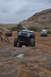 1991 Ford Bronco - Multiple Jeeps navigate a challenging rocky terrain in a desert landscape.