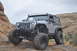 1991 Ford Bronco - This modified Jeep Wrangler JK is navigating a rocky off-road trail under a cloudy sky.