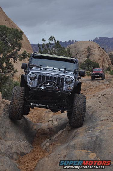 Jeep Wrangler navigating a rocky off-road trail, front right tire elevated