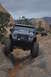 1991 Ford Bronco - A Jeep Wrangler tackles a challenging rocky path with another Jeep visible in the background.