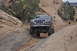 1991 Ford Bronco - A black Ford Bronco navigates a challenging rocky trail with its front end angled towards the camera.