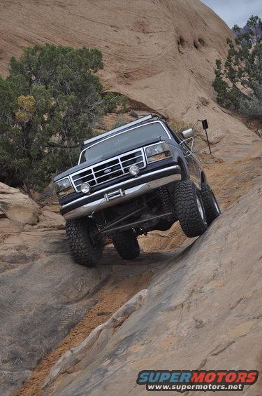 Dark blue Ford Bronco climbing rocky terrain, 1992 model year