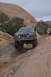 1991 Ford Bronco - Ford Bronco navigating a challenging rocky off-road course in a desert landscape.