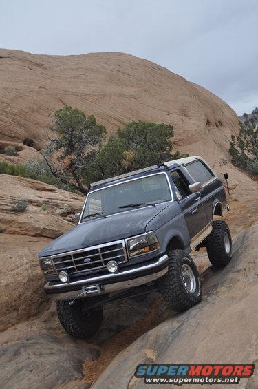 1991 Ford Bronco climbing rocks, front grille and winch visible