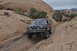1991 Ford Bronco - A lifted Ford Bronco navigates a challenging rocky terrain, with another vehicle following in the distance.