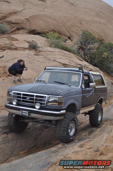 1991 Ford Bronco, 3q-front view, dark gray with light roof and light bar, off-roading