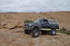 1991 Ford Bronco - This lifted Ford Bronco navigates a rocky, desert landscape under a cloudy sky.