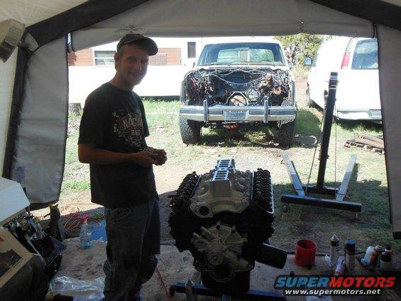 Engine on stand in front of disassembled truck