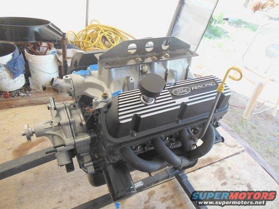 Ford Racing valve covers on an engine assembly mounted on a stand. Oil dipstick is visible