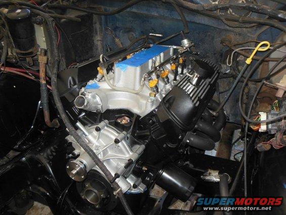Engine with silver intake manifold, black valve covers, and chrome water pump