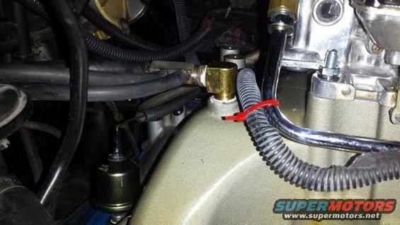 Close-up of engine intake manifold with fuel lines and a fuel filter