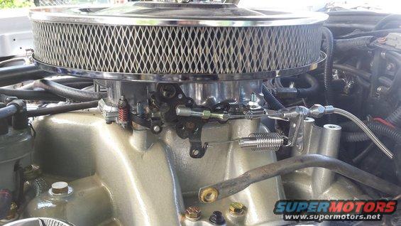 Chrome air filter assembly over a gold intake manifold with throttle linkage