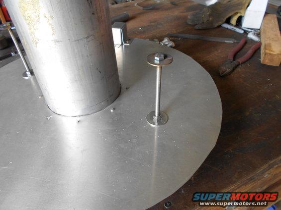 Close-up of a metal disc with a central pipe and a bolt with a washer securing it
