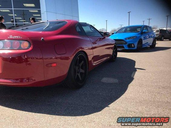 Red 1994 Toyota Supra parked next to a blue Ford Focus