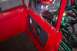 1974 Ford Bronco - Close-up view of the red interior door panel and frame of a vehicle, showing the door handle and part of the interior.