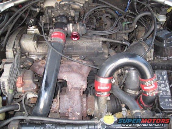 engine bay with turbocharger and custom piping. Toyota branding visible on engine cover