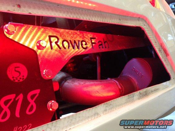 Custom exhaust pipe with 'Rowe Fab' and '818' markings, under red lighting