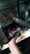 1985 Jeep CJ7 - A hand installs a starter motor onto an engine block, with visible exhaust manifold and engine components.