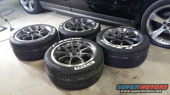 Four Pirelli P Zero tires mounted on multi-spoke aftermarket wheels, with a car's body visible in the background