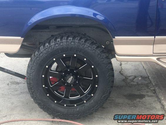 Blue and tan SUV wheel with black Moto Metal rims and off-road tires