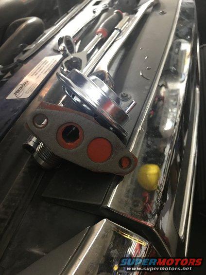 EGR valve and some wrenches on top of an engine bay