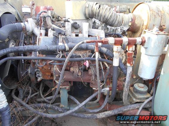 Engine compartment with rusted components and exposed wiring