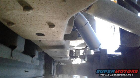 Close-up of a metal exhaust pipe section attached to vehicle undercarriage